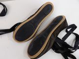 pair of black shoes tied up on a table with a black ribbon