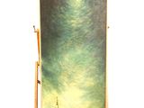 painting on easel with a painting of a landscape in the background