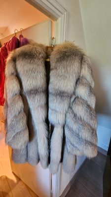 un manteau de fourrure suspendu à un portant dans une pièce