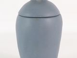 un petit vase bleu avec un ours sur le couvercle