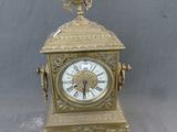 une horloge en or surmontée d'un oiseau