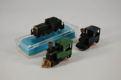 deux petits trains assis l'un à côté de l'autre sur une surface blanche