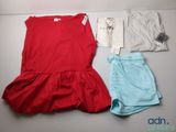une robe rouge et un short bleu posés sur une table