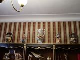 une photo d'une pièce avec de nombreux tableaux accrochés au mur