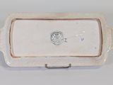 a close up of a white ceramic tray with a blue seal on it