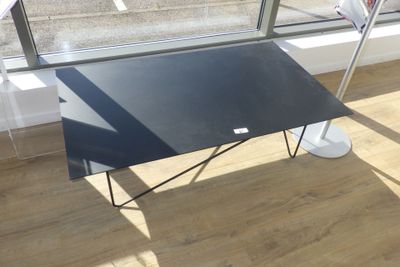 une table noire avec un plateau noir devant une fenêtre