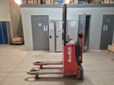 un chariot élévateur rouge garé dans un entrepôt