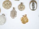 a lot of silver and gold charms on a white surface