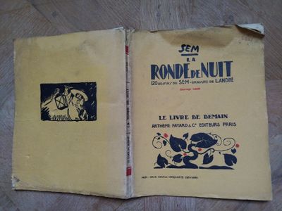 un vieux livre posé sur une table en bois, à côté d'un autre livre