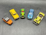 several toy cars are lined up in a row on a metal surface
