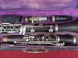two clarinets in a purple case on a red surface
