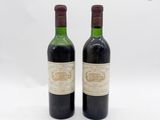 deux bouteilles de vin posées l'une à côté de l'autre sur une surface blanche