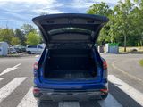 the back end of a blue car with its trunk open