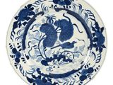 blue and white plate with a bird and flowers on it