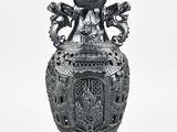 a black vase that is sitting on a white surface