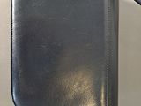 leather purse with zipper on top of it sitting on a table