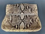a snake skin purse on a blue surface