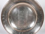 une assiette en argent antique sur fond blanc avec un fond blanc
