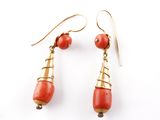 une paire de boucles d'oreilles en corail rouge et en or sur fond blanc
