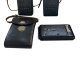 trois téléphones portables et un portefeuille sont posés les uns à côté des autres
