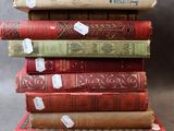 plusieurs vieux livres empilés les uns sur les autres, sur lesquels sont collés des autocollants