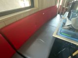une photo d'une cabine rouge et noire sur laquelle est posée une tasse de café