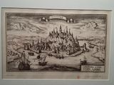 an old drawing of a castle surrounded by ships in a body of water