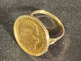une bague en or surmontée d'une pièce de monnaie