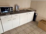 un micro-ondes et un four à micro-ondes posés sur un plan de travail dans une cuisine
