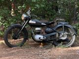 a black motorcycle that is parked in the dirt