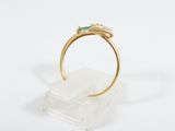 a close up of a gold ring with a green stone