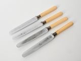 a set of four knives with wooden handles sitting on top of a table