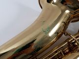 a close up of a gold saxophone on a white surface