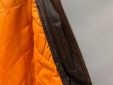 the jacket is orange and brown with a zipper on the back