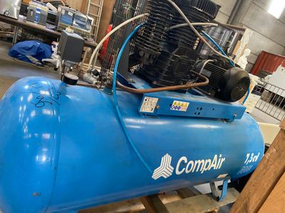 a blue air compressor sitting on a pallet in a warehouse