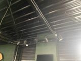 a room with a television and some lights on the ceiling