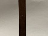 a wooden cross on a stand with a tag on it