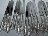 six knives and a knife holder on a table