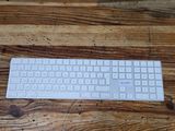 a white keyboard sitting on top of a wooden table
