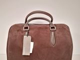 a brown handbag sitting on top of a white table