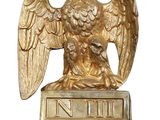 golden eagle with crown on top of a post with a sign