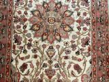 an antique persian rug with a floral design on a white ground