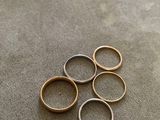five gold and silver rings on a gray surface