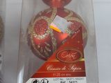 two red and gold ornaments in a clear box