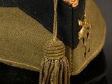 a hat with a tassel on it on a black surface