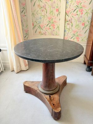 une petite table avec un plateau en marbre dans une pièce