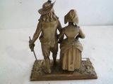 une statue en bronze d'un homme et d'une femme se tenant par la main