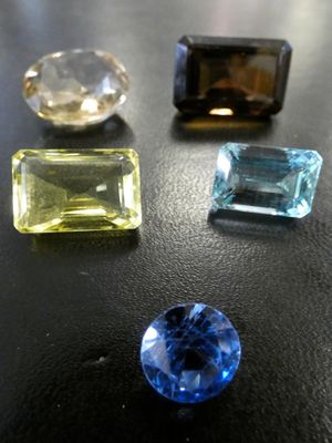 un gros plan sur trois pierres précieuses de couleurs différentes posées sur une table
