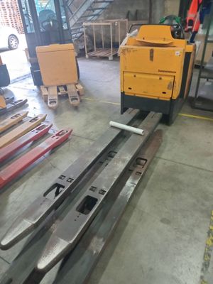 a forklift in a warehouse with many pieces of wood on the floor