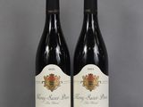 two bottles of wine sitting on top of a table next to each other